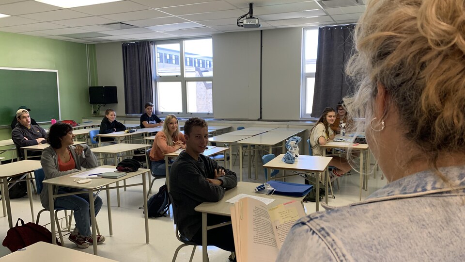 Une professeure lit un livre à des étudiants.