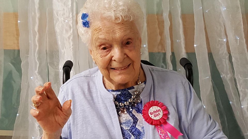 Gilberte Gervais assise dans un fauteuil roulant lors de la célébration de son 100e anniversaire.