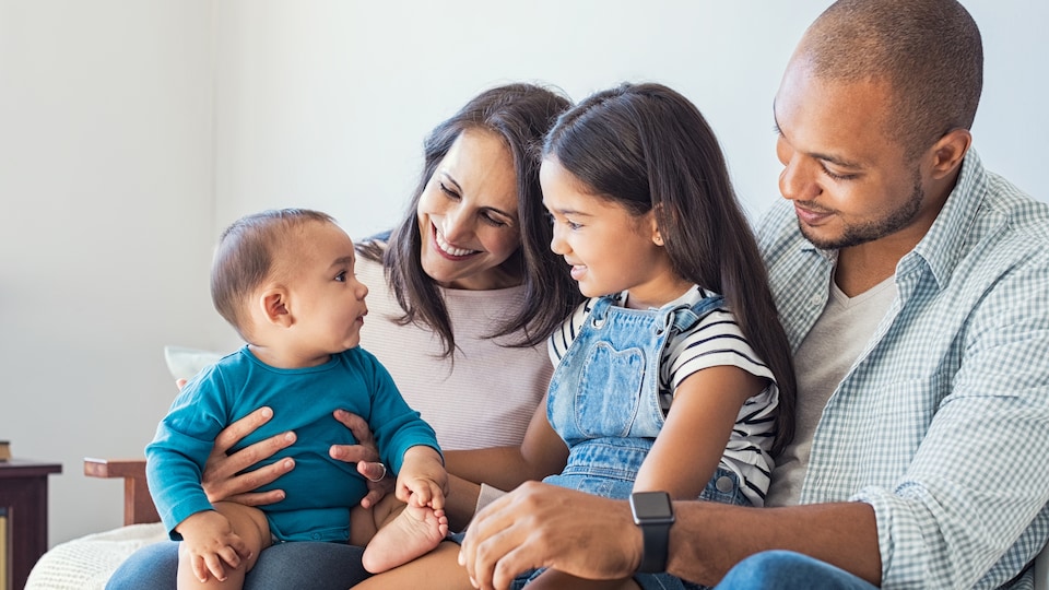 Des parents s'amusent avec le bébé de la famille.