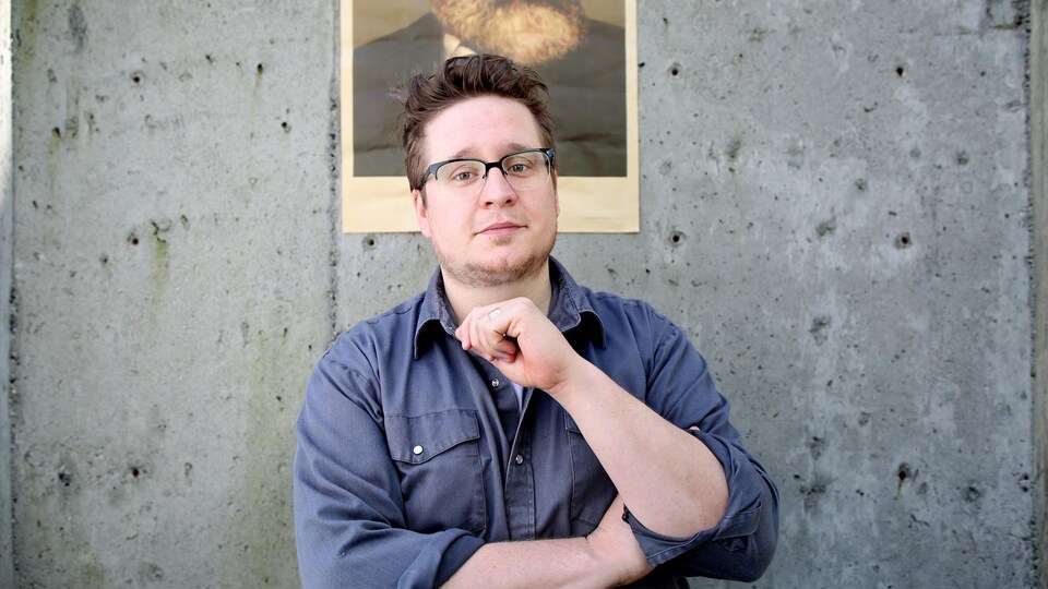 Charles Demers pose devant un mur de béton .