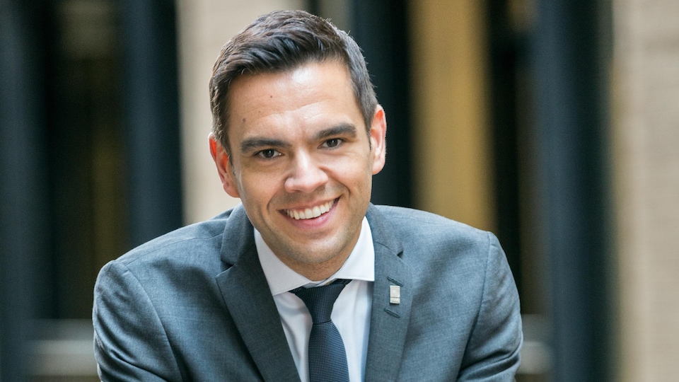 A man leaning against the balustrade smiled as he held out his hands.