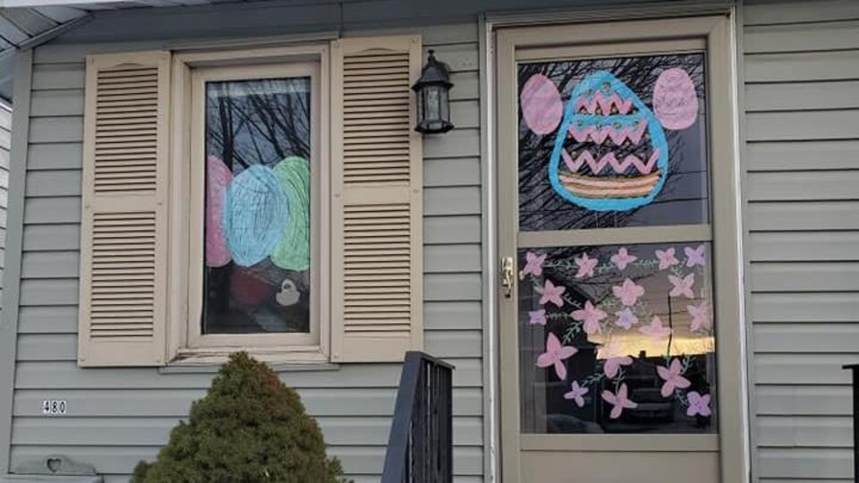 Des peintures d'enfants montrant des œufs de Pâques décorent une maison.
