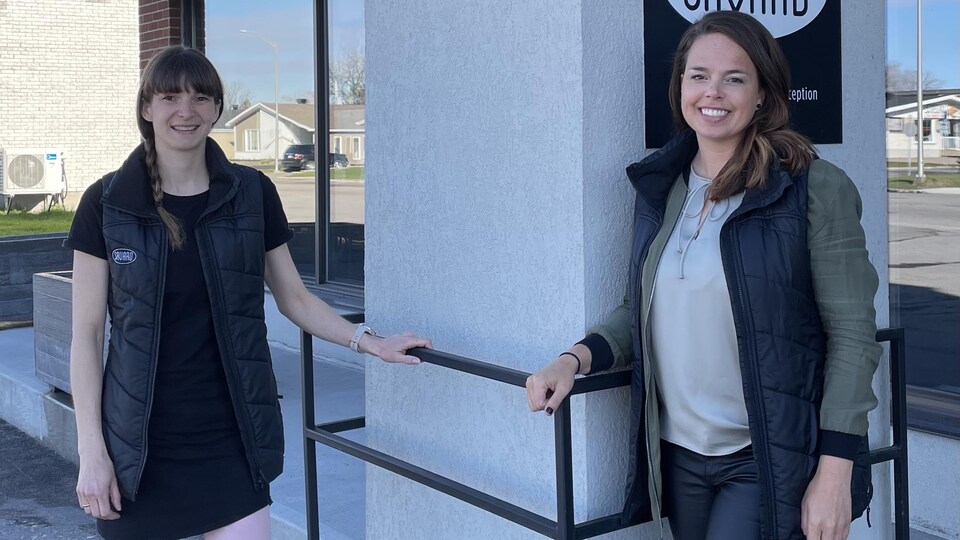Les deux propriétaires de Chaussures Savard posent devant le commerce.