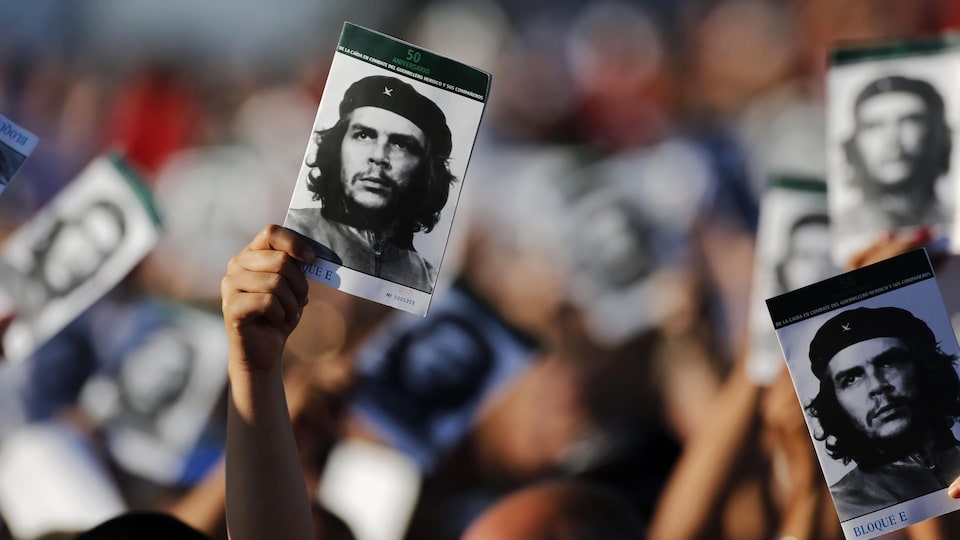 Des gens agitent des photos de Che Guevara pour rendre hommage à ce héros de la révolution cubaine.