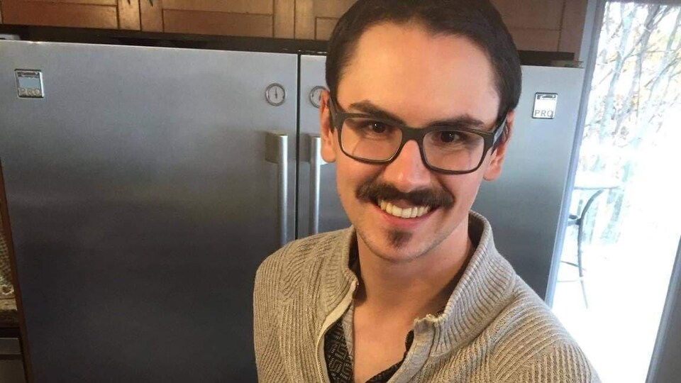 Un homme souriant présente un plateau de viande variées d'une main.
