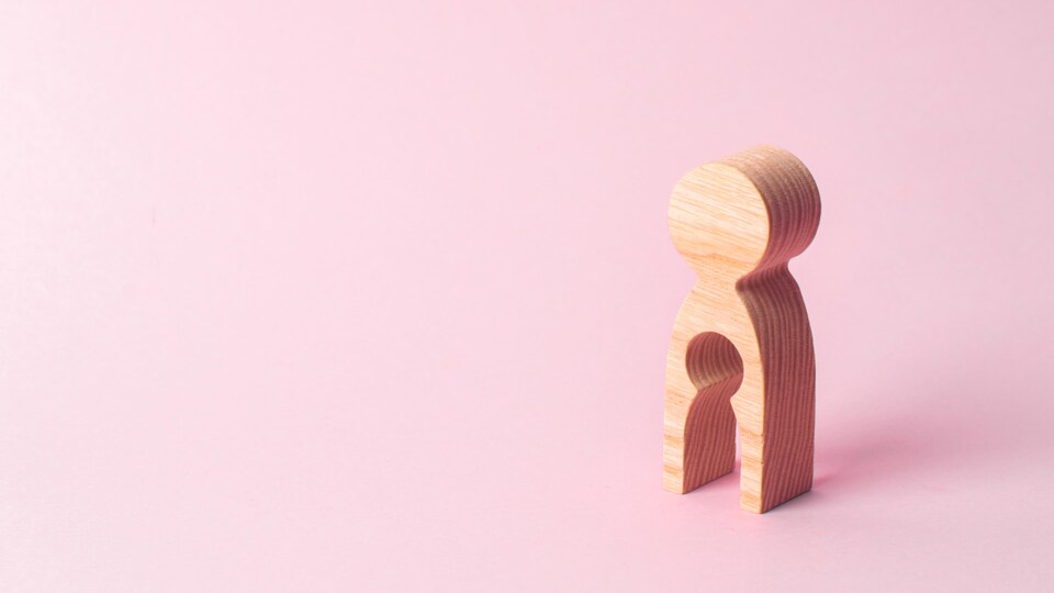 Une figure de bois qui a un trou au niveau du ventre.