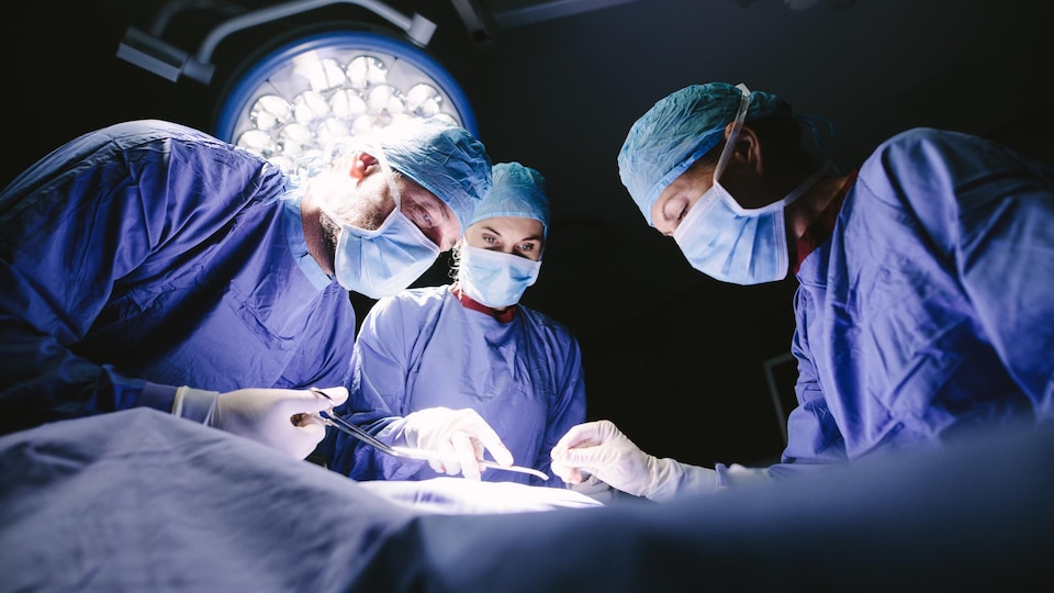 Des chirurgiens autour d'une table d'opération.