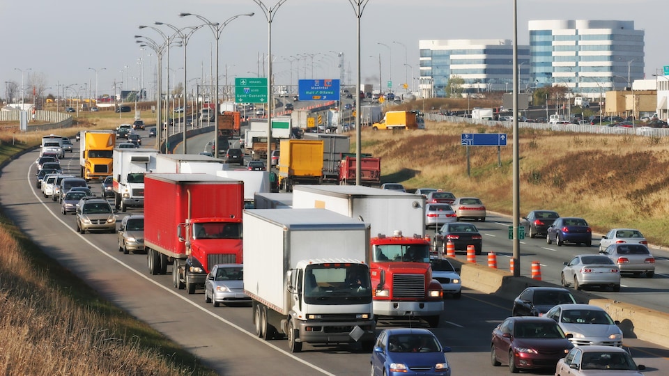 Des camions et des voitures roulent sur une autoroute.