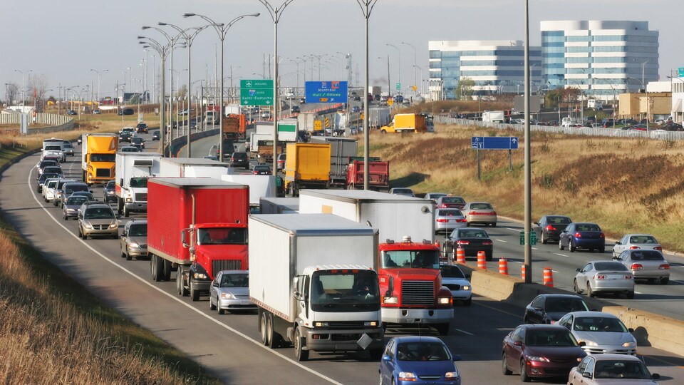 Des camions et des voitures roulent sur une autoroute.