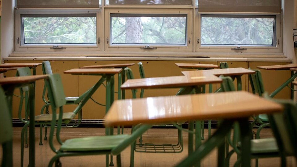 Une classe vide remplie de pupitres.