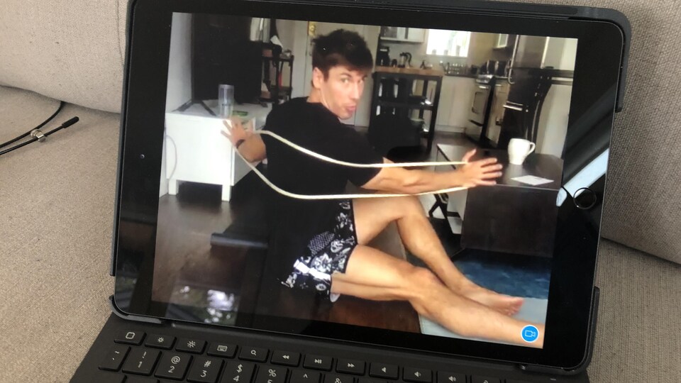 Un portable est ouvert avec l'image de Clément Duranceau qui fait des exercices au sol.