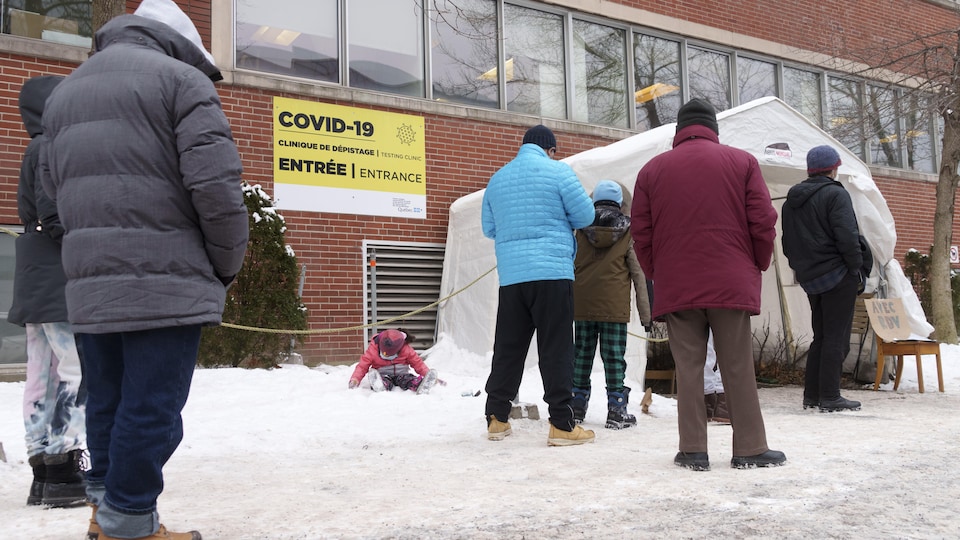 Des gens font la queue devant une clinique de dépistage de la COVID-19, à Montréal.