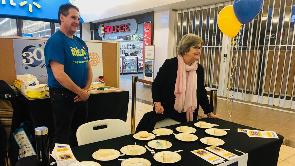 Yves Pothier et Diane Potvin, du Club Rotary de Seot-Îles, offrant des morceaux de gâteau aux Galeries montagnaises