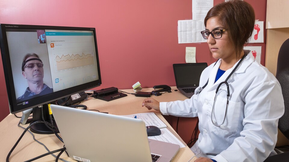 Médecin assise à son ordinateur, en consultation virtuelle