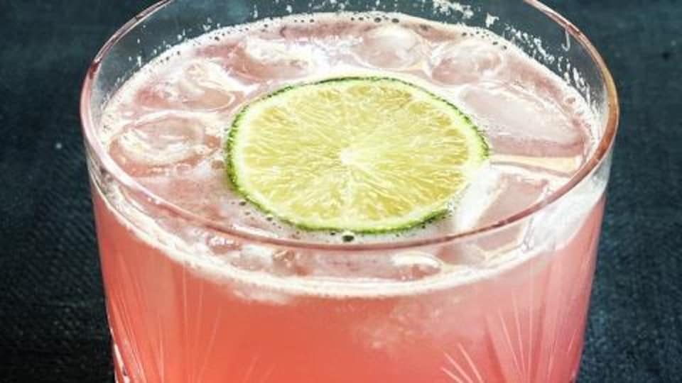 Un cocktail à la rhubarbe est servi dans un verre.