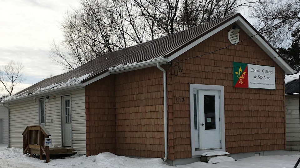Un bâtiment, qui ressemble à une cabane est sur de la neige. 