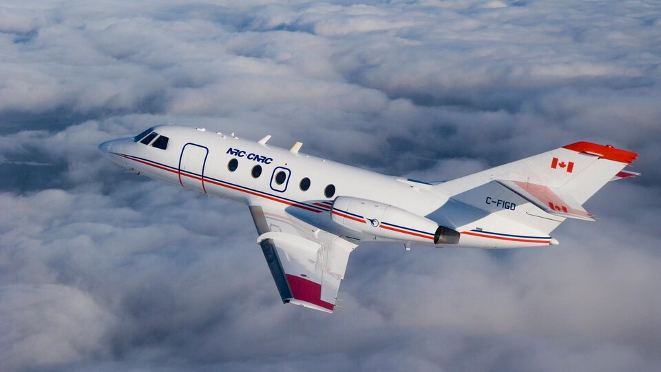 Un avion Falcon-20 du Conseil national de recherches Canada vole dans le ciel.