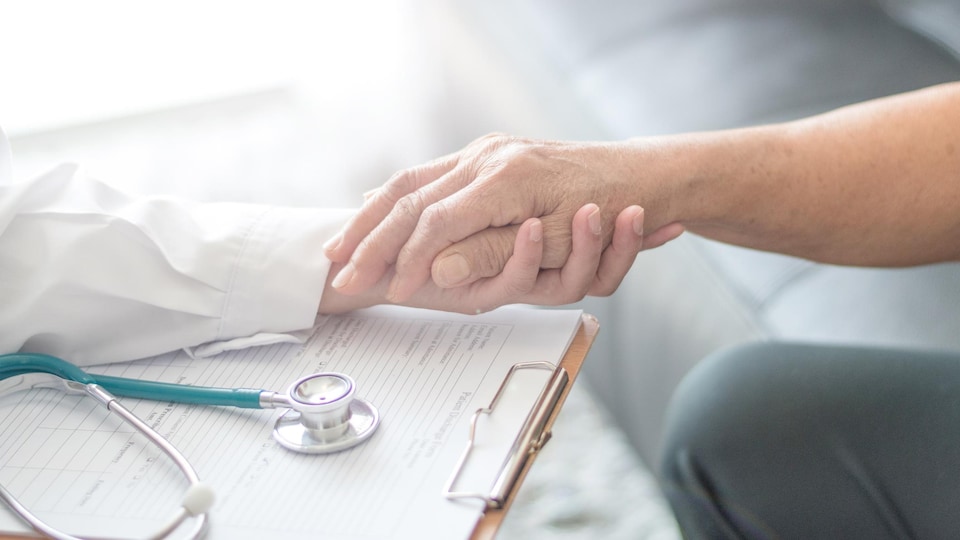 Un médecin tient la main d'une femme souffrant de la maladie de Parkinson.