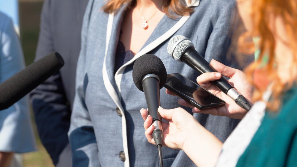 Une politicienne répond aux questions des journalistes.