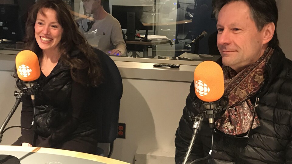 Une femme et un homme assis dans un studio.