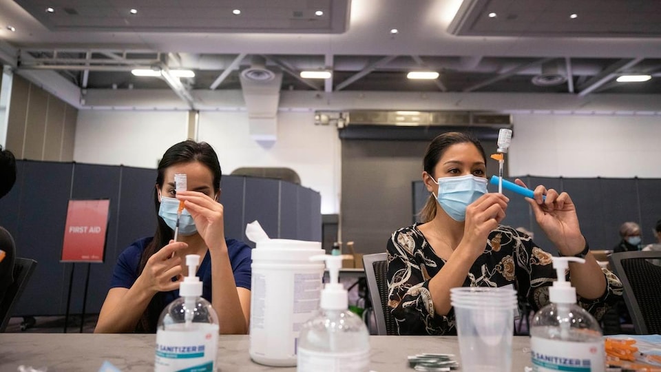 Des employés de la santé se préparent à vacciner.