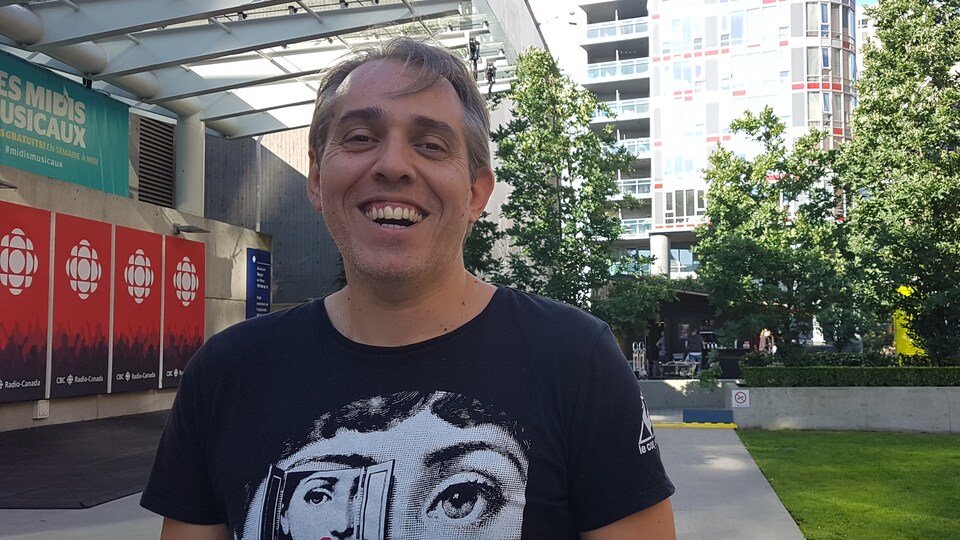 Un homme est photographié à l'extérieur, sur la terrasse de l'édifice de Radio-Canada.