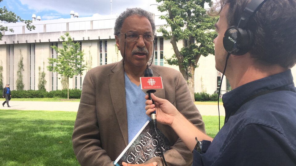 Le professeur Daniel Pauly est à l'extérieur devant un micro en entrevue avec Arnaud Decroix.