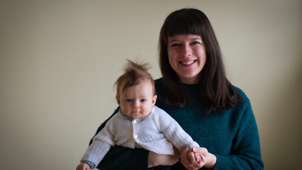 Une maman avec son bébé dans ses bras posent pour la caméra. Toutes deux suivent des cours de danse parent-bébé à l'école DansEncorps de Moncton. 