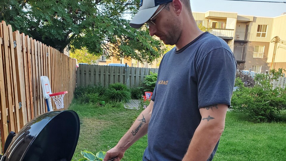 David Leboeuf, directeur du Transit de Sept-Îles, devant son BBQ, dans sa cour.