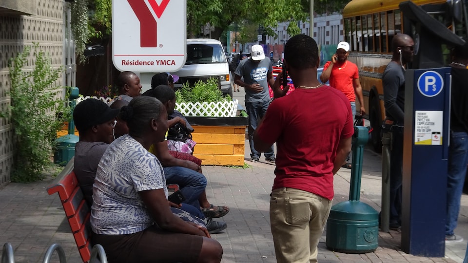 Des personnes noires assises sur un banc public.