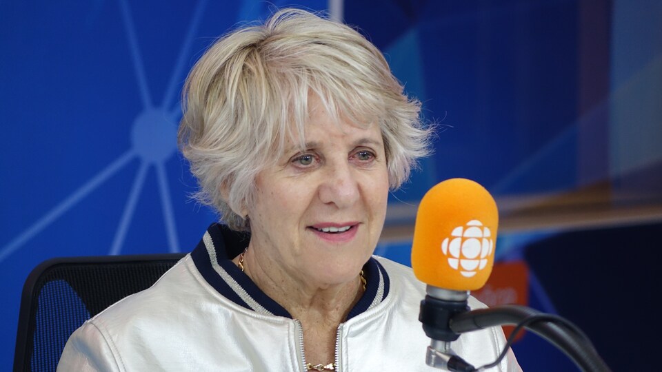Denise Bombardier devant un micro dans un studio radio de Radio-Canada.