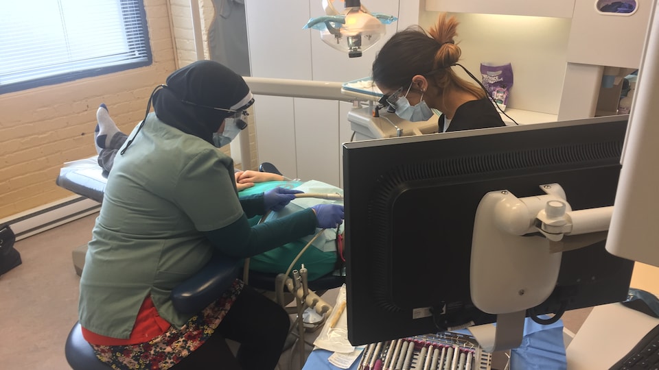 Des dentistes examinent un patient.