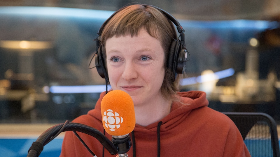 Catherine Dorion, avec des écouteurs sur la tête, assise devant un micro.