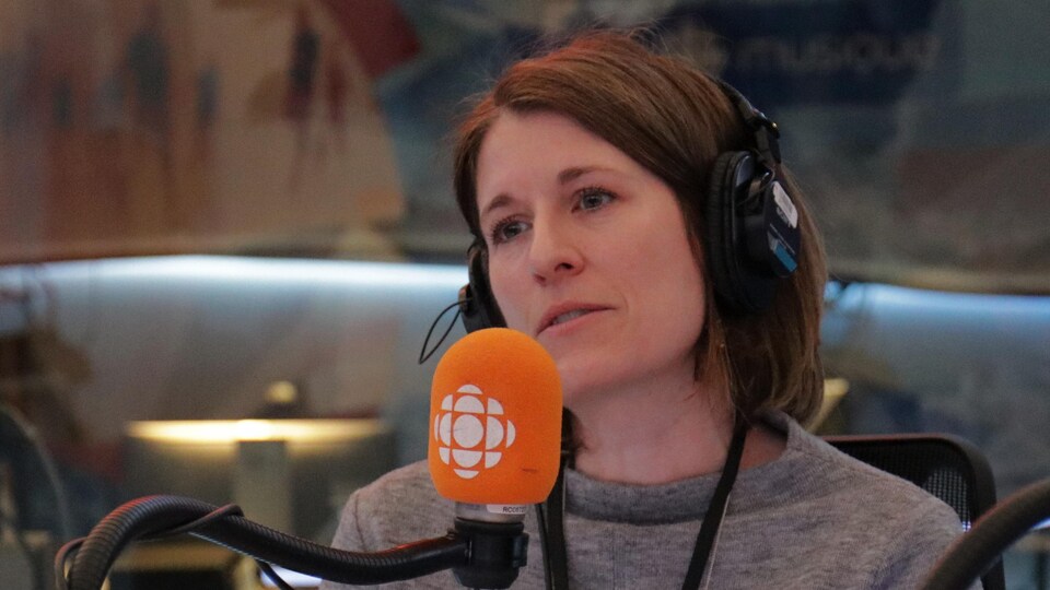 France-Isabelle Langlois devant un microphone dans un studio de radio.