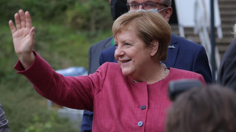 La chancelière allemande Angela Merkel salue des spectateurs.