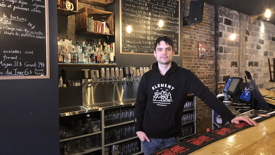 Un homme derrière un comptoir de bar.