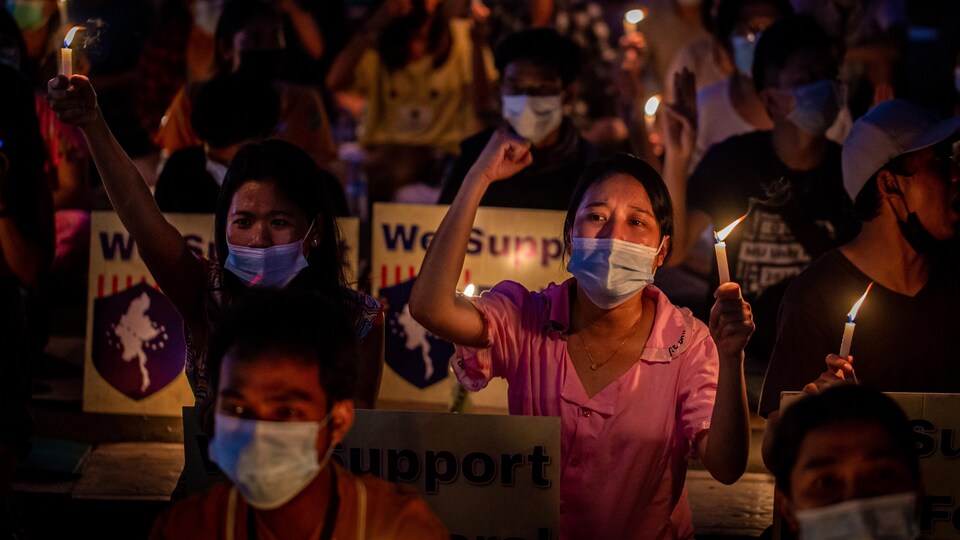 Des personnes manifestent contre le coup d’État militaire au Myanmar, lors d’une veillée à la chandelle.