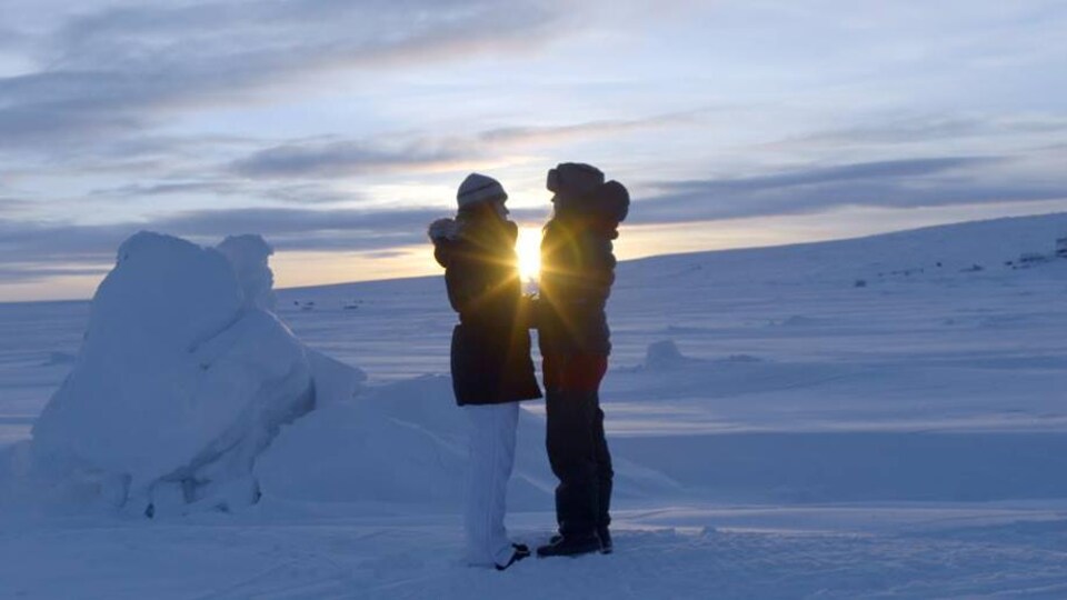 Deux femmes sur une banquise avec un coucher du soleil