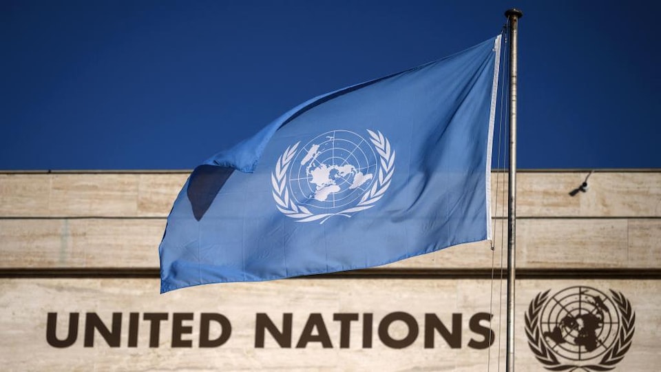 Le drapeau de l'ONU flottant devant le Palais des Nations à Genève.