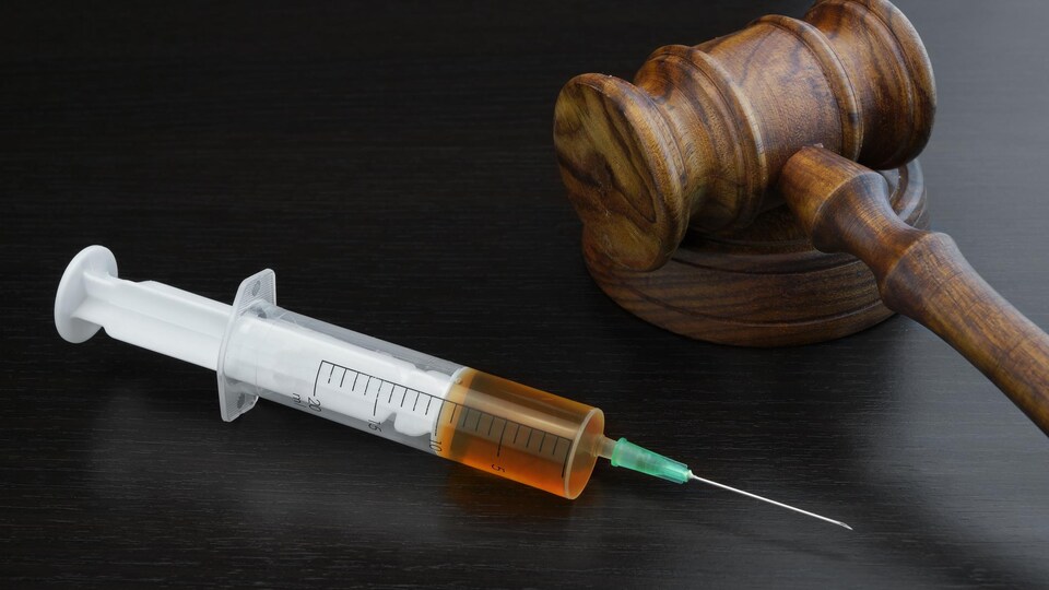 Une seringue et un maillet de juge pour illustrer le rôle des tribunaux dans l'aide médicale à mourir
