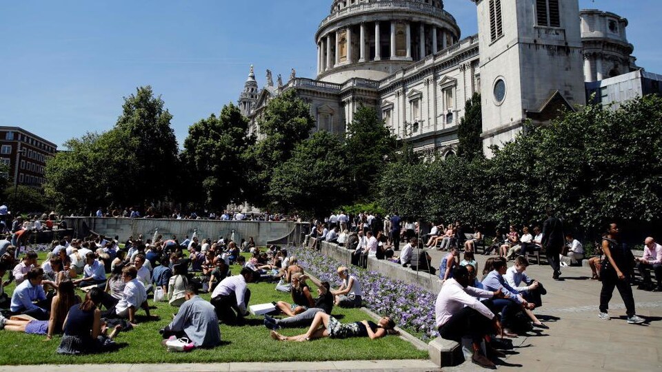 Des gens profitent du soleil à l’extérieur de la cathédrale St Paul à Londres