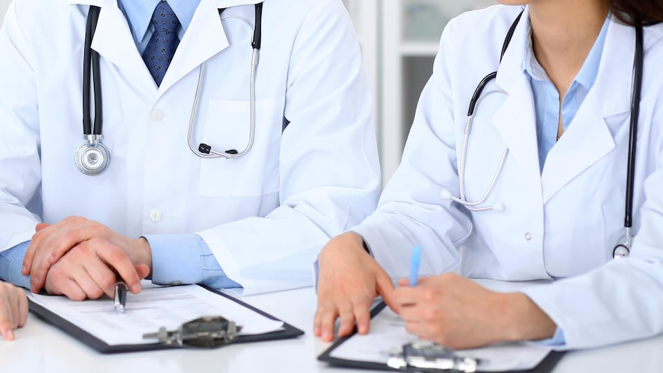 Des médecins assis autour d'une table en train de discuter.