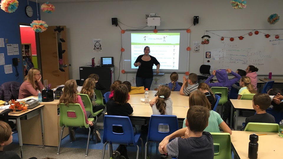 Une enseignante du Québec parle à sa classe dans une école primaire.