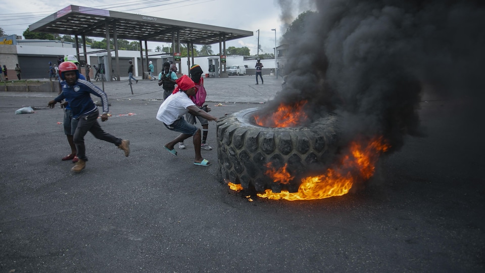 Des manifestants dressent une barricade avec un pneu en feu non loin d'une station d'essence à Port-au-Prince.