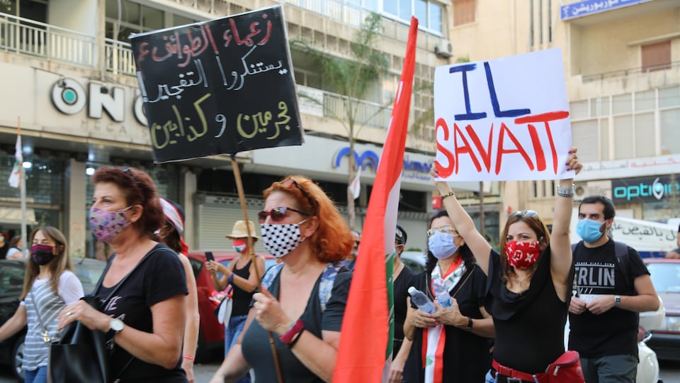 Des gens marchent dans la rue avec des bannières et des slogans pour accuser le gouvernement (libanais) à coup de « Il savait » pour le nitrate d'ammonium.
