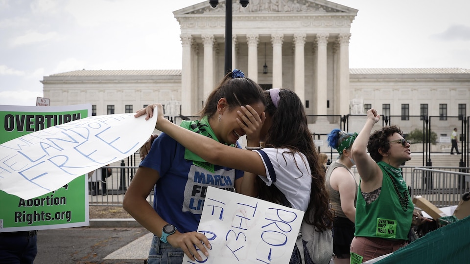 Deux femmes pleurent devant la Cour suprême des États-Unis.