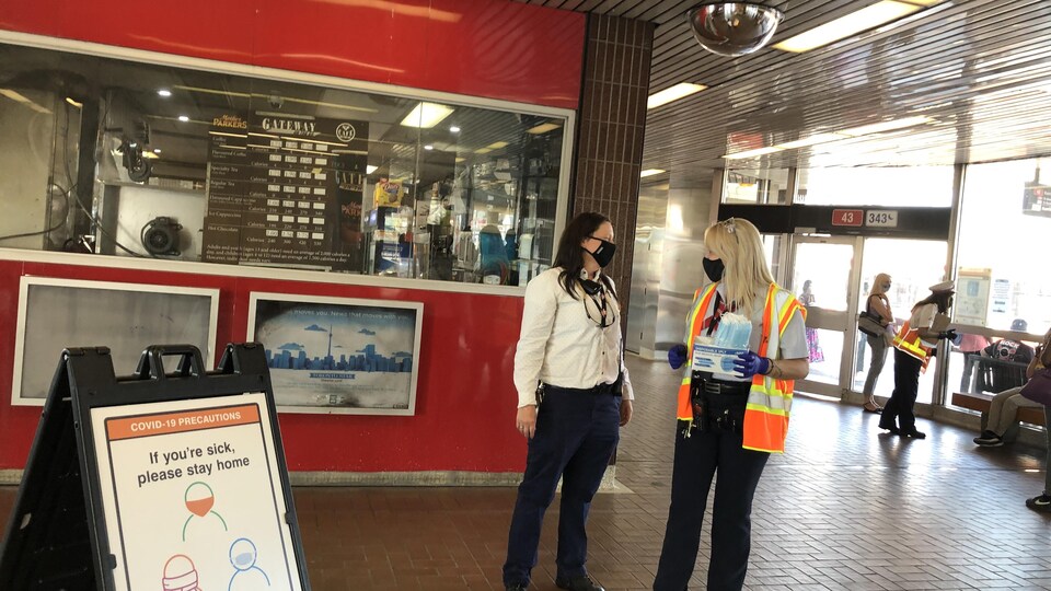 Des employés offrent des masques dans une station de métro de Toronto