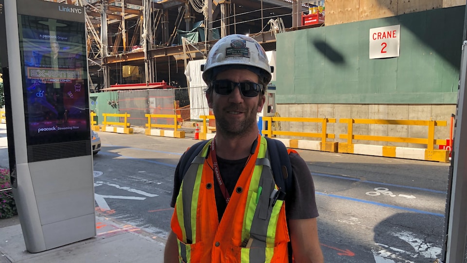 Un travailleur de la construction devant en édifice en construction à New York