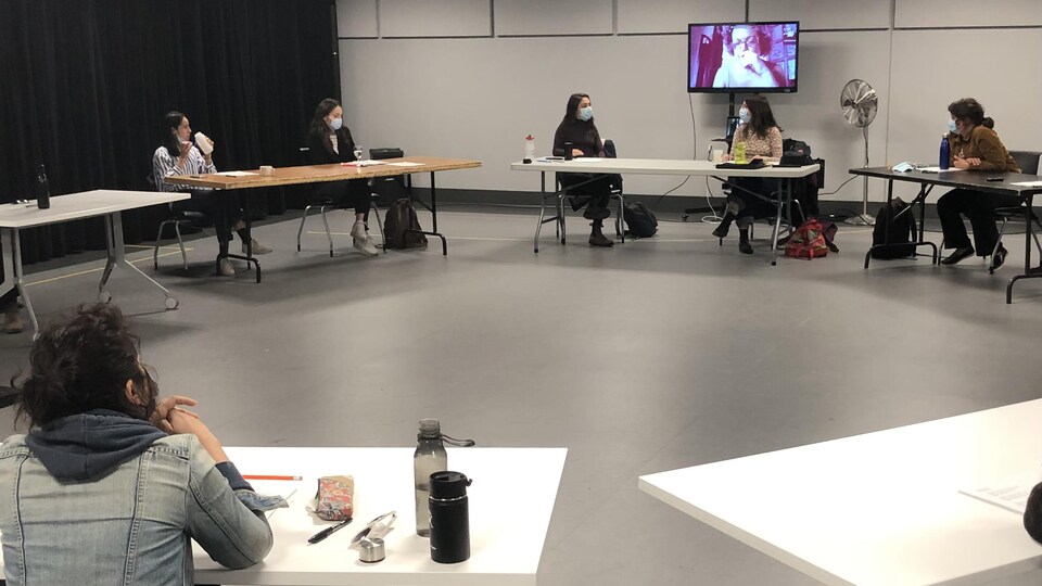Des femmes réunis en cercle dans une salle avec distanciation.