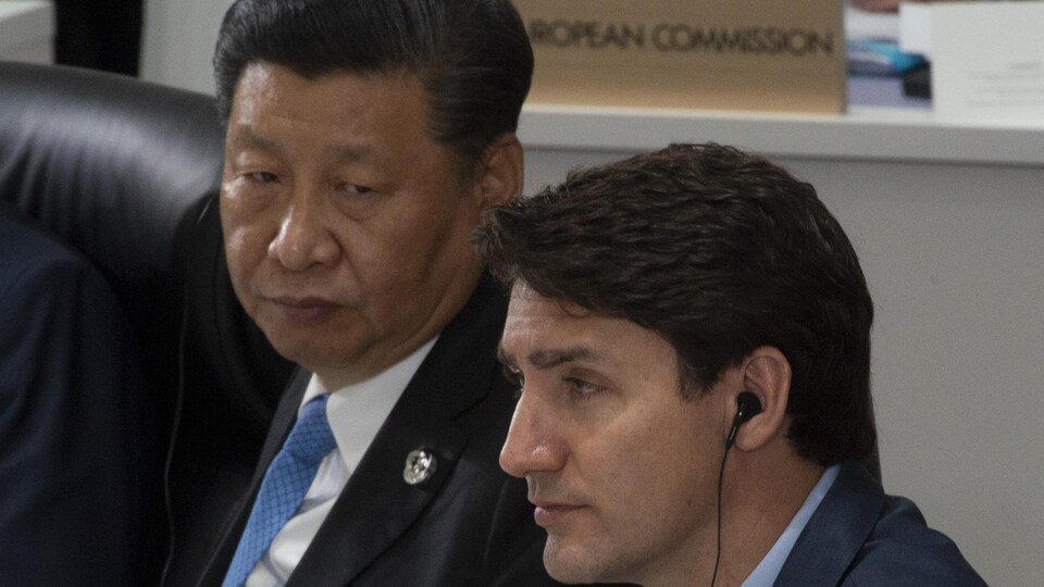 Justin Trudeau et Xi Jinping écoutent les remarques d'ouverture au Sommet du G20 à Osaka, au Japon.
